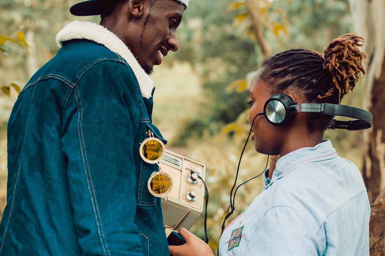 Two people enjoying a vintage radio experience outdoors in Kiambu, Kenya.